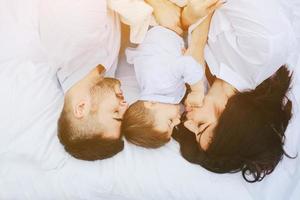 glückliche familie, die sich zusammen auf der matratze entspannt foto