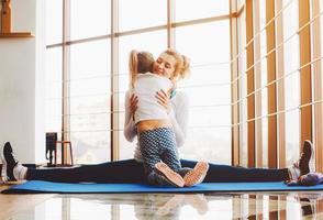 mutter und tochter umarmen sich im fitnessstudio foto