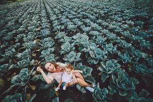 Mutter und Tochter auf dem Feld mit Kohl foto