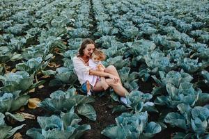 Mutter und Tochter auf dem Feld mit Kohl foto