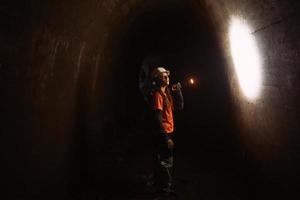 Baggerin mit Taschenlampe erkundet den Tunnel foto