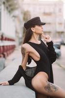 sexy, junge Frau im Trikot, die auf der Straße vor der Kamera posiert foto