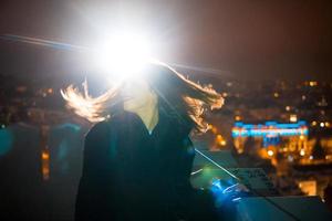 Frau auf dem Hintergrund des Stadtbildes bei Nacht foto