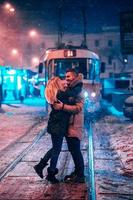 junges erwachsenes Paar auf der verschneiten Straßenbahnlinie foto