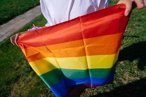 Zugeschnittenes Foto einer jungen Frau mit LGBT-Stolzflagge.