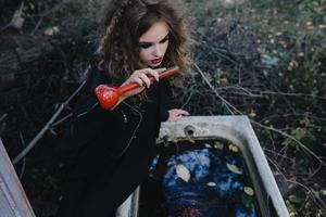 Vintage Hexe mit Elixier in der Hand foto