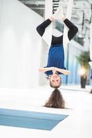 Porträt eines schönen jungen Mädchens, das sich mit Fliegenyoga auf Leinwänden beschäftigt. foto