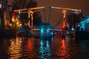 Nachtbeleuchtung von Gebäuden und Booten im Kanal. foto