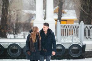 Paar posiert in einem verschneiten Park foto