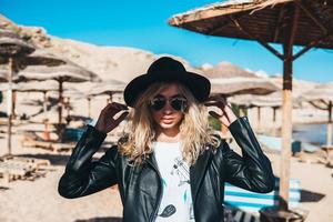 junge Frau mit Strohhut und Sonnenbrille am Strand foto