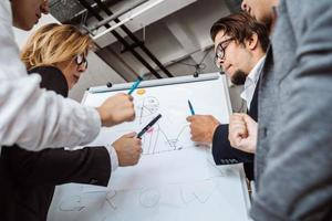 geschäftsleute mit whiteboard diskutieren strategie in einer besprechung foto