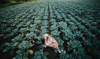 Mutter und Tochter auf dem Feld mit Kohl foto