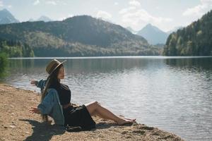 das mädchen im kleid und hut des sees in den bergen foto