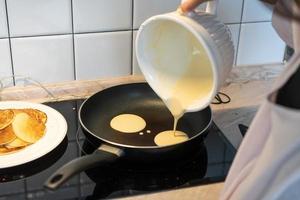 süße Pfannkuchen werden in einer Pfanne gebraten. foto