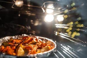 Bratkartoffeln mit Karotten und anderen Gewürzen im Bräter. foto