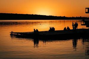 Menschen ruhen am Ufer des Flusses. Sonnenuntergang foto