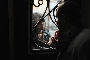 Europäisches junges Paar, das sich durch das Fenster ansieht foto