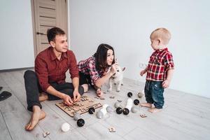 Glückliche Familie spielt zusammen auf dem Boden foto