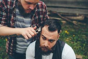 Friseur rasiert einen bärtigen Mann foto