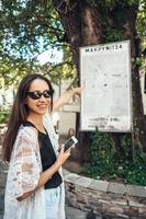 Frau zeigt auf die Karte der Wahrzeichen der Stadt. Makriniza foto