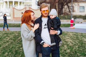 glückliche Mutter, Vater und Sohn, die sich im Park umarmen foto