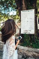 Frau zeigt auf die Karte der Wahrzeichen der Stadt. Makriniza foto