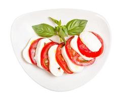 Draufsicht auf Mozzarella und Tomate mit Basilikumzweig foto