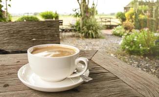 Kaffeetasse auf dem Tisch mit Blick auf den Garten Hintergrund foto