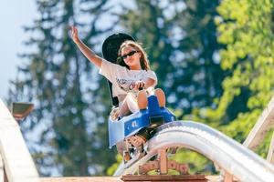 Mädchen geht mit ausgestrecktem Arm auf einer Bergachterbahn über die Brücke foto