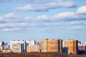 blauer Himmel mit Wolken über städtischen mehrstöckigen Häusern foto