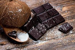 Schokolade und Kokosnuss auf altem Tisch foto