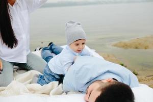 glückliche junge familie, die sich zusammen auf dem see entspannt foto