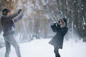 Mann und Frau werfen Schneebälle foto