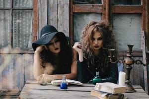 Zwei Vintage-Hexen führen ein magisches Ritual durch foto