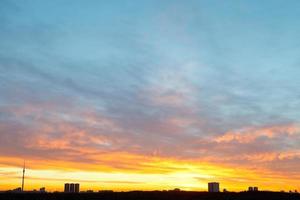 Gelber und blauer Sonnenaufgangshimmel über der Stadt foto