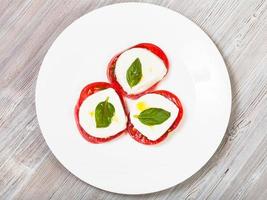 Draufsicht auf Mozzarella, Tomate, Basilikum in Stapeln foto