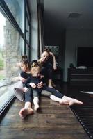 Mutter und zwei Töchter zusammen am Fenster foto