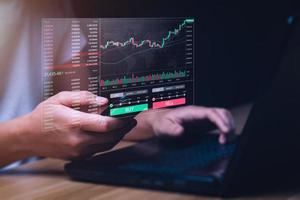 Krypto-Trader-Investor-Broker mit Handy und Laptop für die Finanzmarktanalyse von Kryptowährungen. Devisenhandel, Aktienmarkt und Wirtschaftswachstumsdiagramm. digitale Vermögenswerte foto