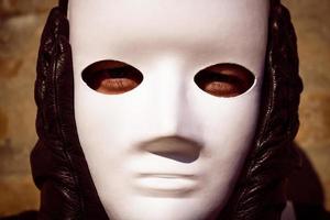 Nahaufnahme einer Person mit weißer Maske über dem Gesicht. foto