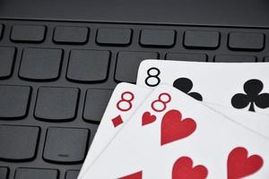 Pokerpapierkarten auf leerer Laptop-Tastatur, weicher und selektiver Fokus, Konzept für das Online-Spielen von Karten mit anderen Menschen zu Hause und Freizeitaktivitäten. foto