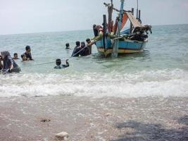 Lamongan, Jawa Timur, Indonesien, 2022 - Kleines Boot mit Kindern hält am Strand foto