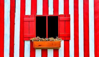 rotes Fenster auf roter und weißer Holzwand