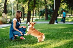 Porträt einer Frau mit Hund Welsh Corgi Pembroke im Hundepark foto