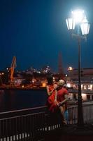 Mann und Mädchen umarmen sich vor dem Hintergrund des Nachthafens foto
