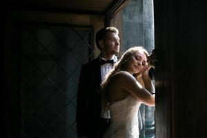 Braut und Bräutigam in einem gemütlichen Haus, fotografiert mit natürlichem Licht aus dem Fenster. foto