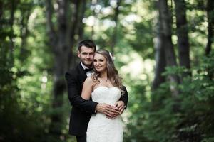 schönes Hochzeitspaar posiert im Wald foto