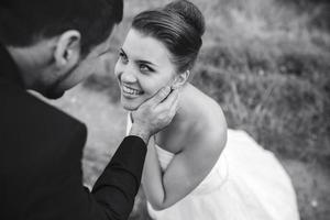 Bräutigam berührt sanft das Gesicht seiner Braut foto