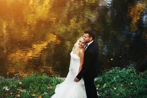 schönes Hochzeitspaar posiert im Wald foto