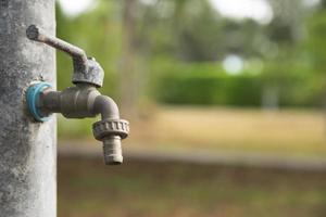 ein alter Wasserhahn mit Spinnennetz foto