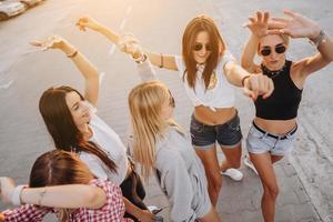 Fünf junge Frauen tanzen auf einem Parkplatz foto